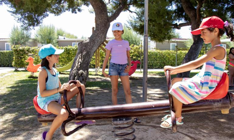 Kinder spielen auf einer Wippe im sonnigen Park.