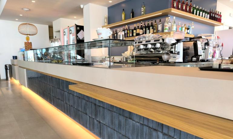 Elegante bar moderno con luci calde e atmosfera accogliente.