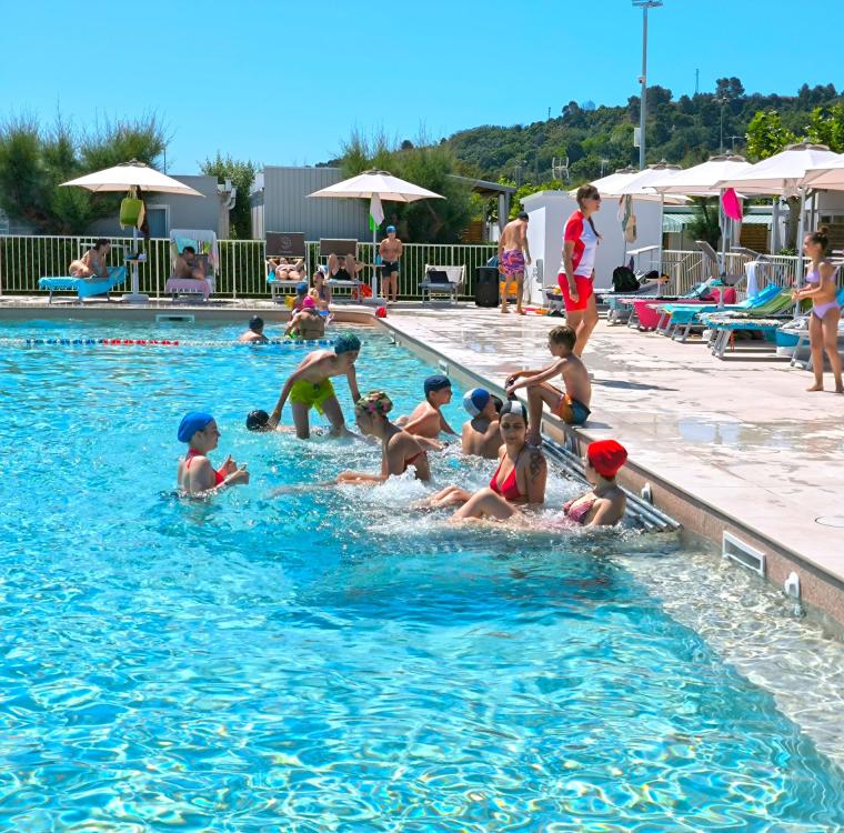 Piscina estiva, bambini giocano felici, sole splendente, atmosfera di relax.