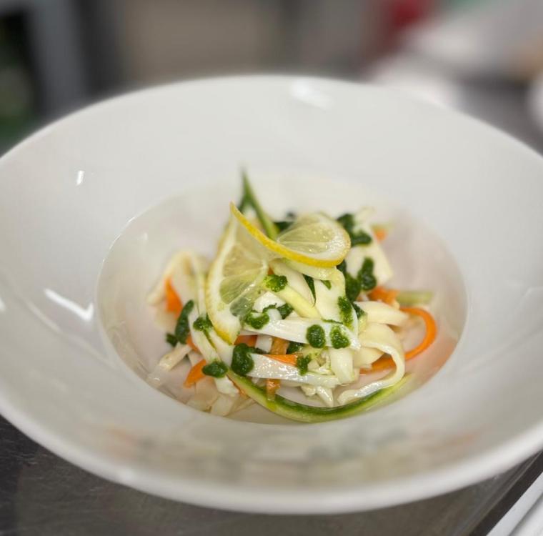 Piatto di pasta fresca con verdure colorate, limone e salsa verde.