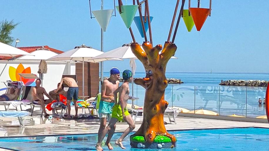 Piscina all'aperto, sole, divertimento estivo con amici e giochi d'acqua.