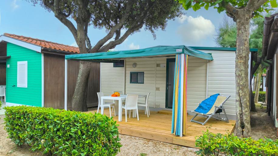 Casetta accogliente con veranda, natura rigogliosa e atmosfera serena.