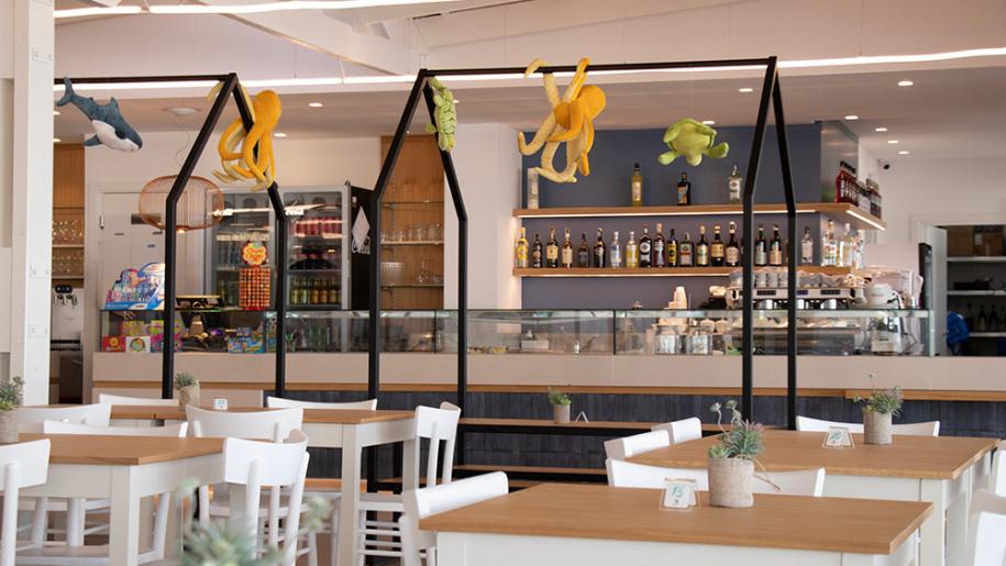 Caffetteria luminosa con decorazioni marine e atmosfera accogliente.